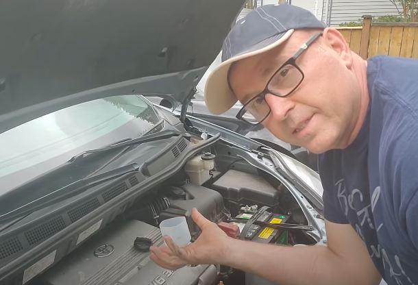 Rob Kenny demonstrating how to change car oil. 