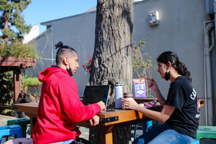 Jasmine Guerrero(right) and Daniel Aguilar (left) enjoying coffee at the Grind and discussing classwork.