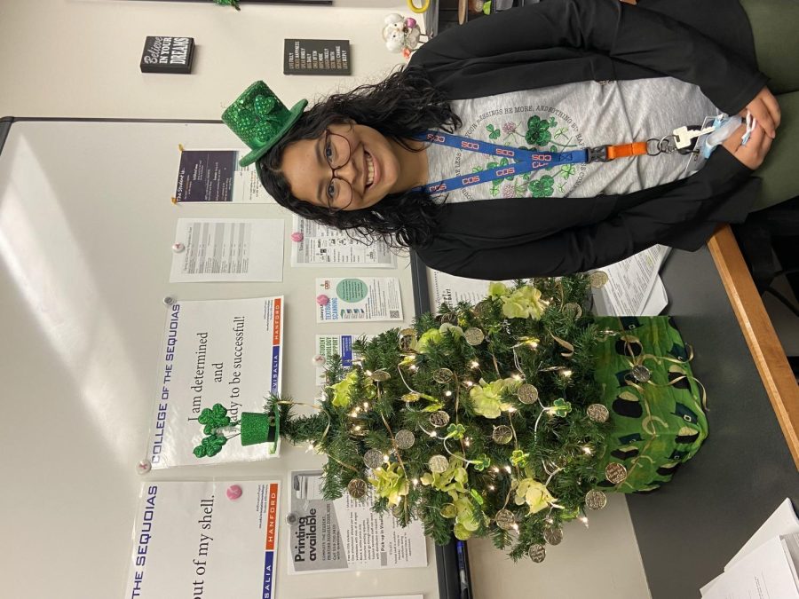 Clerical+assistant+Vanessa+Lopez+posing+in+front+of+St.+Patricks+Day+decorations+in+the+Access+and+Ability+Center